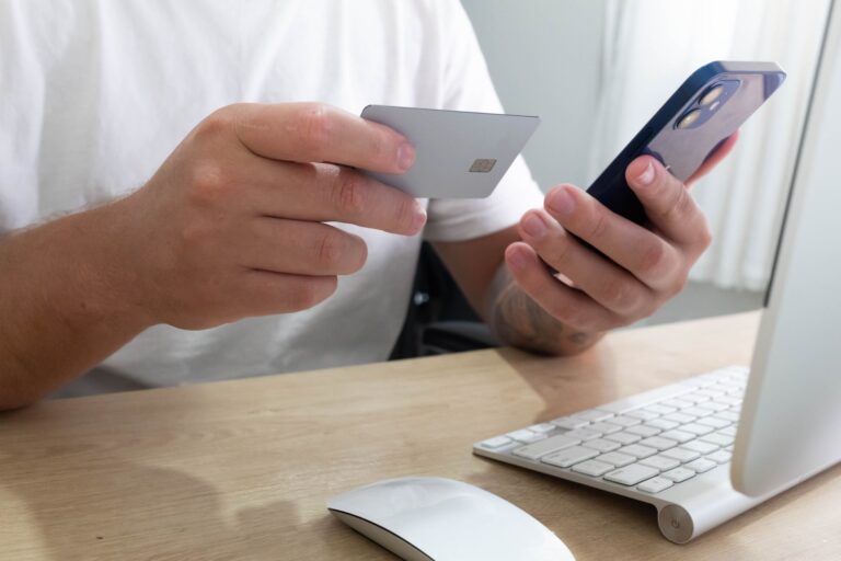 Krypto-Debitkarten: So funktionieren sie und worauf du achten solltest Krypto-Debitkarten – Person bezahlt mit Karte und Smartphone
