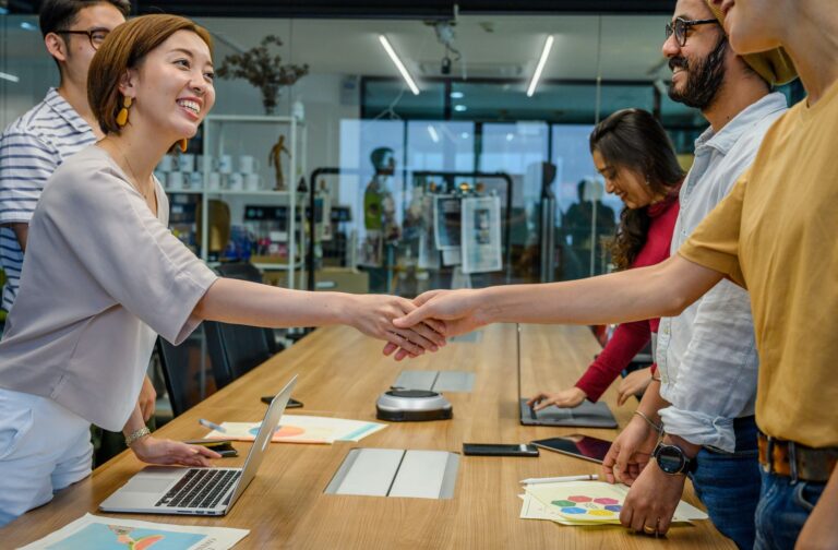 Mitarbeiterbindung in Startups – Teammitglieder geben sich im Büro lächelnd die Hand
