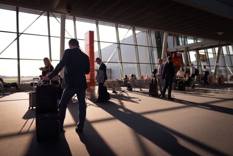 Konferenzreise ins Ausland – Geschäftsreisende mit Gepäck im Flughafenterminal
