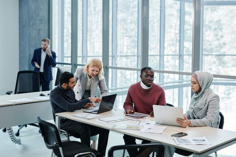 KI-Tools für Startups – Team bespricht Arbeitsabläufe an Laptops im Büro