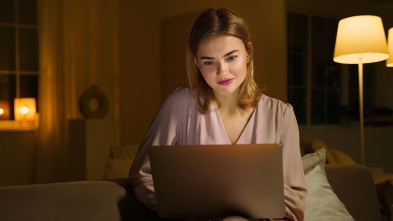 Nebenberuflich selbstständig – Frau arbeitet abends am Laptop