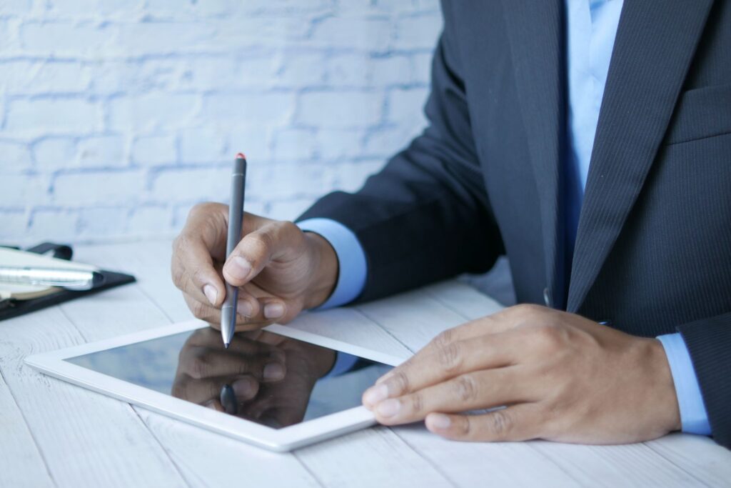 GmbH gründen – Person unterzeichnet Unterlagen digital auf dem Tablet