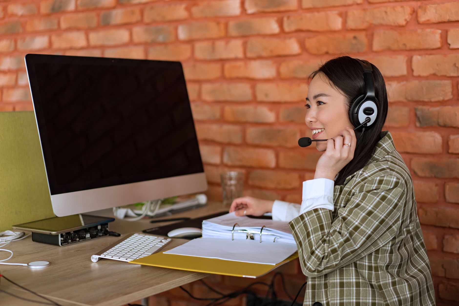 Kaltakquise – Person mit Headset bereitet ein Verkaufsgespräch am Schreibtisch vor