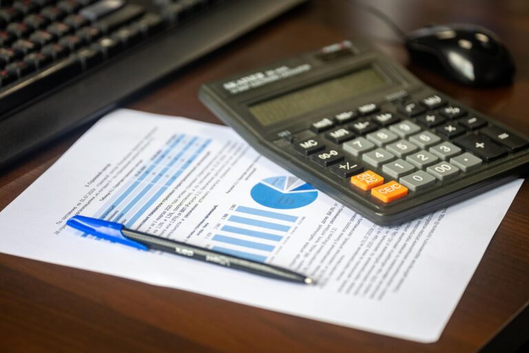 Umsatzsteuer für Gründer – Taschenrechner und Finanzbericht auf dem Schreibtisch